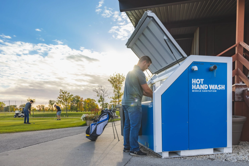 Worker walking past a job site portable toilets unit.